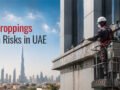 Bird droppings health risks in the UAE shown on a commercial building with a professional bird control technician inspecting contamination from a manlift